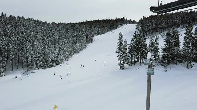 ROGLA, SLOVENIA, 2019.01.29: View from ski lift crossing ski slope with skiers. Filming beautiful ski resort on cold sunny winter day.