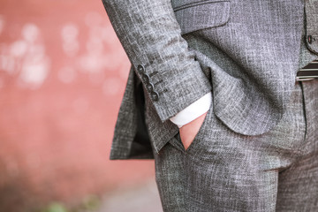 a man in a suit put his hand in his pocket