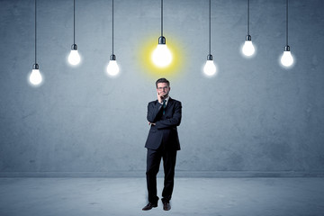 Obraz premium Handsome businessman in an empty space with bulbs above and uninspired face 