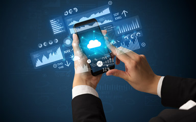 Female hand using smartphone with financial tracking concept illustrated by graphs and symbols