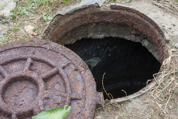 Opened unsecured sewer,abandoned rusty hatch with open sewerage