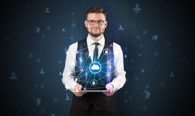 Secured cloud hologram on tablet  holded by spectacled young businessman in suit
