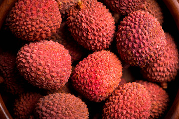 Red ripe lychees on the rustic background. Selective focus. Shallow depth of field.