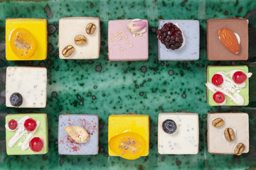 Dessert.  Assorted fruit pastries made from natural products on a beautiful, green plate. Cakes with fresh berries and nuts. Top view.
