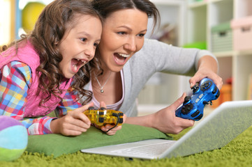 portrait of happy mother and daughter playing game