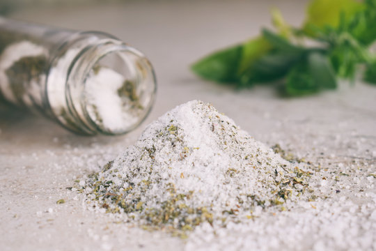 Ayurvedic herbal salt in glass jar. Sea salt with aromatic herb - rosemary, oregano, sage, marjoram, basil, thyme, mint, bay leaf. Copy space