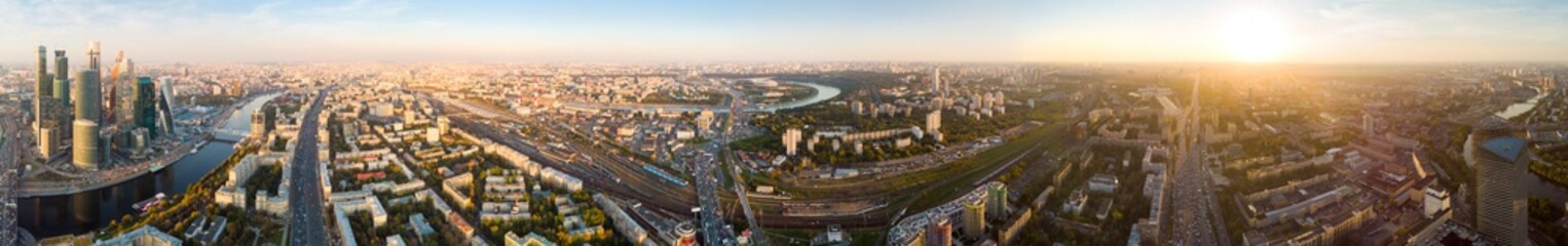 Fototapeta na wymiar panorama high-rise buildings and transport of metropolis, traffic and blurry lights of cars on multi-lane highways and road junction at sunset in Moscow.