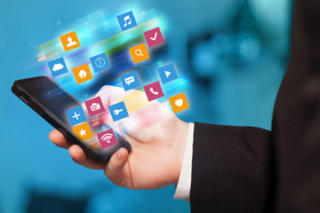 Hand using phone with colorful fast moving application icons and symbols concept
