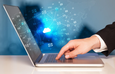 Hand using laptop with cloud computing and online storage concept
