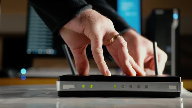 A man disconnects the ethernet cables from the WAN port and LAN ports of the WiFi router
