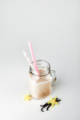 Protein cocktail with milk, vanilla in a glass jar with straws. Sports nutrition