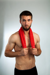Attraktiver bärtiger Mann mit einem roten Handtuch
