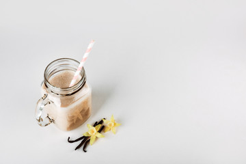 Protein cocktail with milk, vanilla in a glass jar with straws. Sports nutrition
