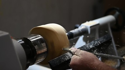 woodturner creates a bowl with with chisel on rotating wood