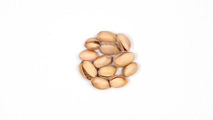 Pistachio nuts on a white background. Nuts are lying around.