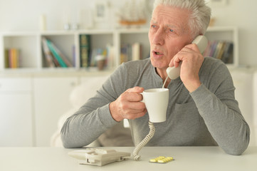 Portrait of elderly ill man calling to hospital