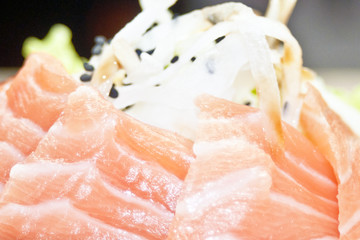Raw salmon slice or salmon sashimi in Japanese style fresh serve on ice with fresh wasabi photo in...