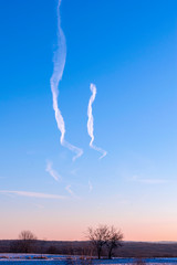 wispy jet trails on blue sky in winter