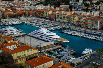 Blick von oben auf den alten Hafen in Nizza mit Häusern und Booten und einer luxus yacht