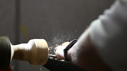 man at woodturning machine making a wooden bowl