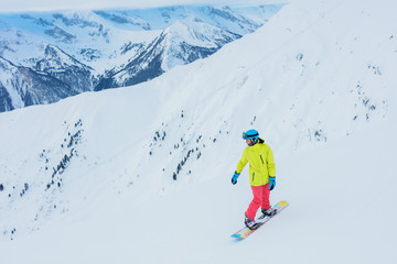 Fototapeta na wymiar Girl snowboarder having fun in the winter ski resort.