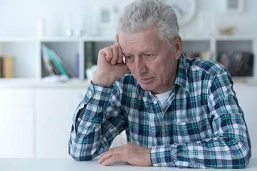 Close up portrait of thoughtful senior man at home