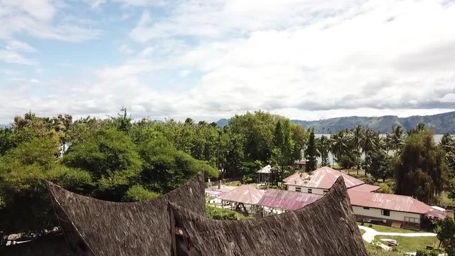 Drone view of traditional Batak houses with lake Toba in the background. Sumatra, Indonesia.