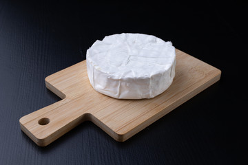 Tasty blue cheese on a wooden board. Prepared Italian dishes on the kitchen table.