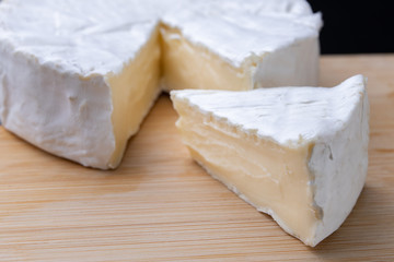 Tasty blue cheese on a wooden board. Prepared Italian dishes on the kitchen table.