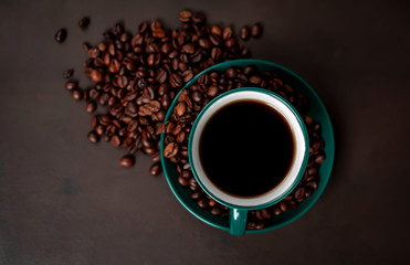 Coffee cup with roasted beans on stone background