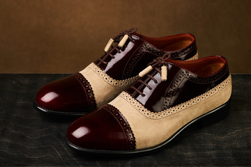 Groom's wedding shoes on a dark wooden box, close-up