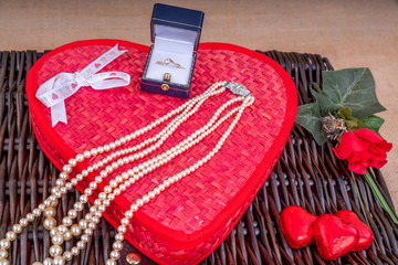 Valentine&rsquo;s Day Gift Hamper.  Diamond Ring and Pearl Necklace and gift box with a wicker hamper with Heart shaped chocolates.