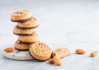Homemade biscuit cookies with almond nuts and peanut butter on marble coasters on white kitchen...