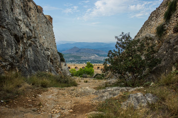 narrow path way between steep mountain rocks outdoor scenic landscape with background unfocused horizon view on European valley 