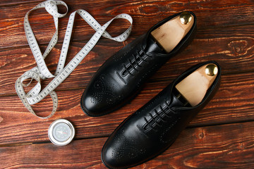 Men's wedding shoes on a brown wooden table, close-up. Business travel concept