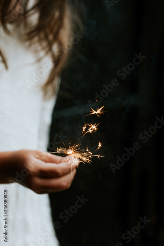 little girl holding sparkle firework