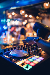 DJ plays live set and mixing music on turntable console at stage in the nightclub. Disc Jokey Hands...