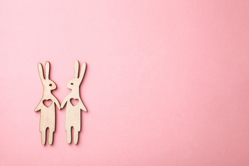 Obraz premium couple of wooden rabbits in love on pink background, flat lay, copy space