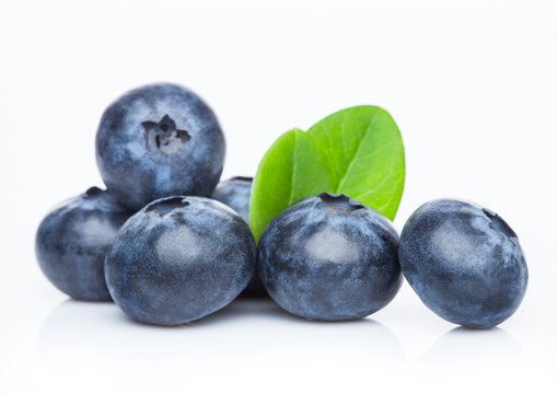 Fresh raw organic blueberries with leaf on white background. Macro close up