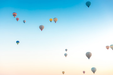 Fototapeta premium Colorful hot air balloons isolated on blue sky background. Colorful hot air balloon flying over at fairy chimneys in Nevsehir, Goreme, Cappadocia Turkey. 