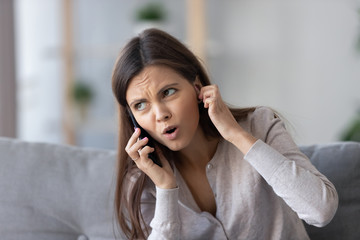 Annoyed young woman talking on the phone not hearing bad signal lost no mobile connection on...