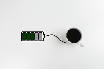 Black coffee and drawn battery charging from it. Concept of getting energy from coffee with copy space. Power charging.