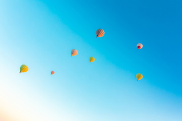 Colorful hot air balloons isolated on blue sky background. Colorful hot air balloon flying over at fairy chimneys in Nevsehir, Goreme, Cappadocia Turkey. 