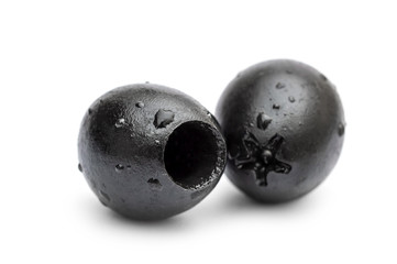 Two pitted black olives on a white background.