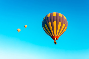 Colorful hot air balloons isolated on blue sky background. Colorful hot air balloon flying over at fairy chimneys in Nevsehir, Goreme, Cappadocia Turkey. 