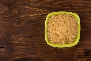 white rice in bowl on wooden table background