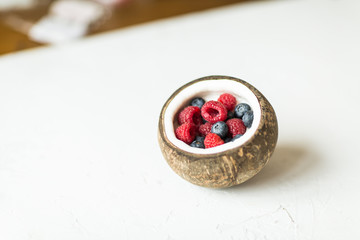 Coconut bowl with fresh berries for healthy vegetarian diet breakfast