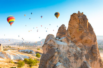 Colorful hot air balloons flying over at fairy chimneys in Nevsehir, Goreme, Cappadocia Turkey. Hot air balloon flight at spectacular Cappadocia Turkey.  