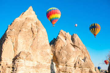 Fototapeta na wymiar Colorful hot air balloons flying over at fairy chimneys in Nevsehir, Goreme, Cappadocia Turkey. Hot air balloon flight at spectacular Cappadocia Turkey. 