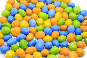 Multicolored glazed chocolate candies on a white